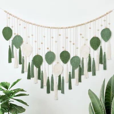 Imagen del producto de Tapiz de pared de macramé, en tonos beige y verde, de 130 x 80 cm, con motivos de hojas y cuentas de madera, ideal para el salón