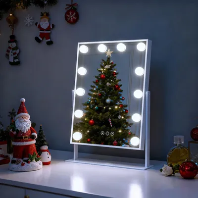 A vanity mirror with lights is placed on a dresser, reflecting a Christmas tree. Christmas decorations are visible in the background and on the dresser.