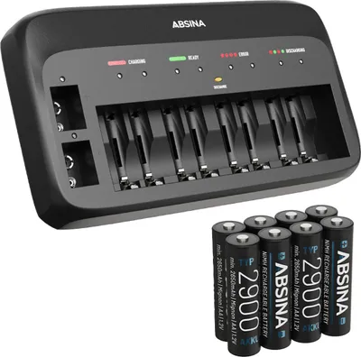 A black battery charger with multiple slots and a set of AA batteries in front of it, all on a white background.