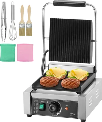 A commercial panini grill with accessories and food items on the grill.