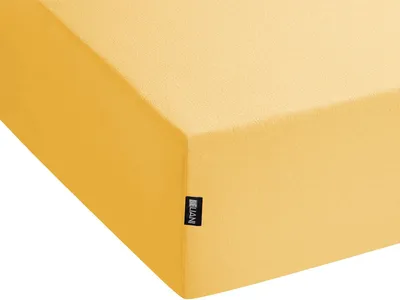 A close-up view of a yellow fitted sheet, showing a corner and a small black label with white text.