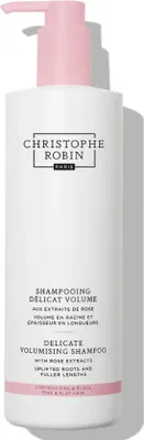 A white bottle of Christophe Robin shampoo with a pink pump dispenser.