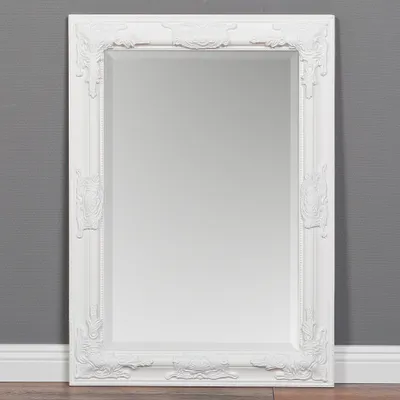 A white baroque-style mirror is displayed against a gray wall and white baseboard.