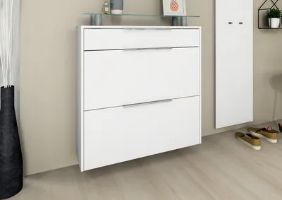 A white shoe cabinet with two drawers is mounted on a light beige wall.