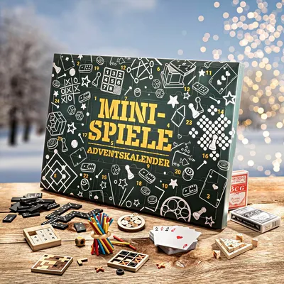 A collection of mini-games and a mini-games advent calendar are displayed on a wooden table in a winter setting with bokeh lights in the background.