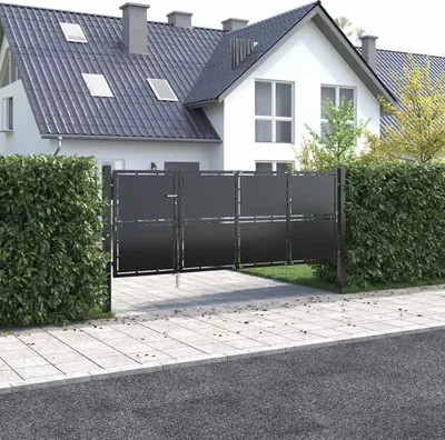 A modern house with a steel gate and manicured hedges.