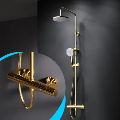 A gold-colored shower system with a rain shower head and a handheld shower head, mounted on a dark gray wall.