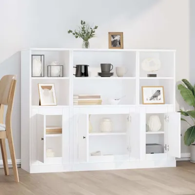 A white wooden sideboard with multiple shelves and doors, decorated with various items.