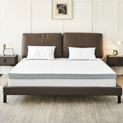 A mattress topper on a bed with pillows and a headboard.