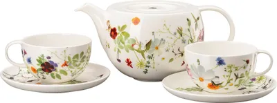 A white porcelain teapot and two teacups with saucers, all decorated with a floral pattern, are arranged on a white background.