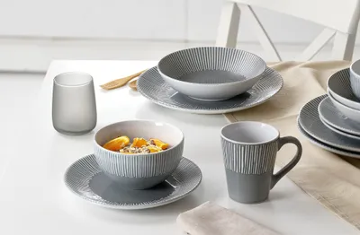 A table setting with a breakfast bowl, mug, and glass.