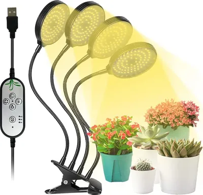 A plant grow light with four adjustable arms is clipped to a stand, illuminating several potted plants.