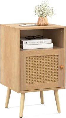 A light wood nightstand with a rattan door and a small vase of flowers on top.