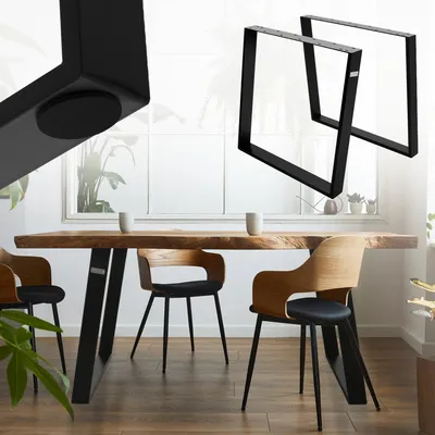 A dining table with black metal legs and wooden chairs in a bright room with a large window.