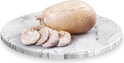A whole salted pig's bladder and several slices of it are presented on a round marble-like cutting board.