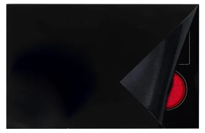 A black induction cooktop with a corner of a protective mat lifted to reveal a red heating element.