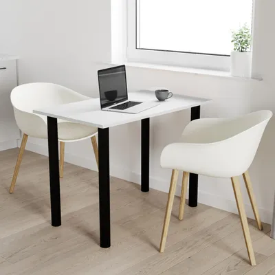 A white table with black legs, two white chairs, and a laptop on the table, placed in a bright room with a window.