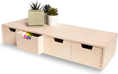 A wooden desk organizer with drawers and plants on top, set against a white background.