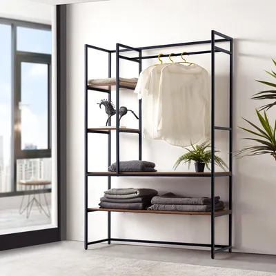 A wardrobe stand with clothes and decorative items, placed indoors near a window.