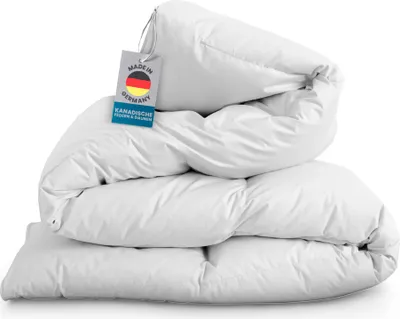 A folded white duvet is stacked on top of itself, with a tag attached to the top duvet.