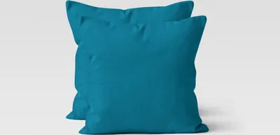 Two teal throw pillows are shown against a white background.