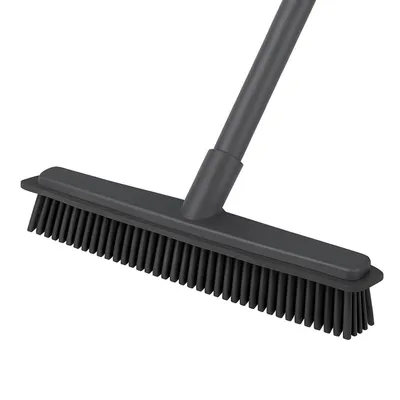A close-up shot of a dark gray rubber broom with a telescopic handle against a white background.
