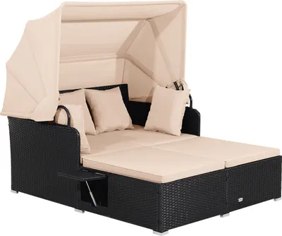 A black rattan daybed with a beige canopy, cushions, and pillows, shown against a white background.