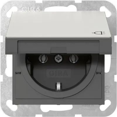 A close-up, front-facing view of a GIRA electrical outlet with its cover open.