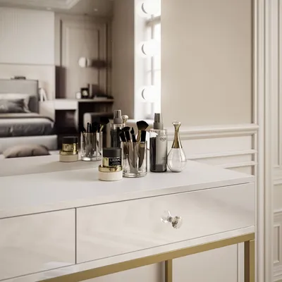 A vanity table with makeup products and a bedroom reflected in the mirror.