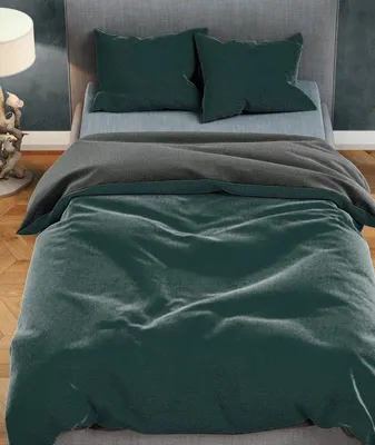 A bed with dark green and anthracite bedding.