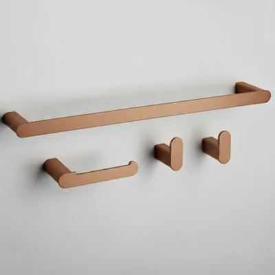 A set of copper-colored bathroom accessories mounted on a light gray wall.