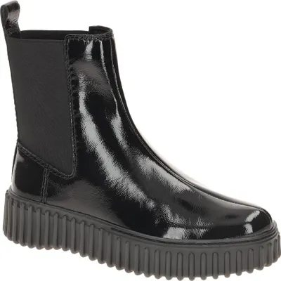 A single black patent leather Chelsea boot with a thick lug sole, shown from a side-diagonal angle against a white background.