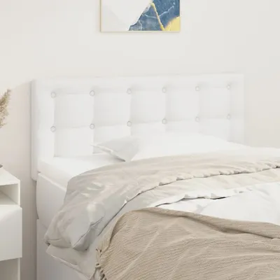 A white tufted headboard is shown behind a bed with white bedding and a beige throw blanket.