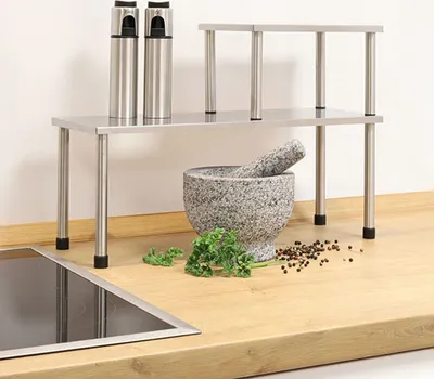 A kitchen shelf with kitchenware on a countertop.