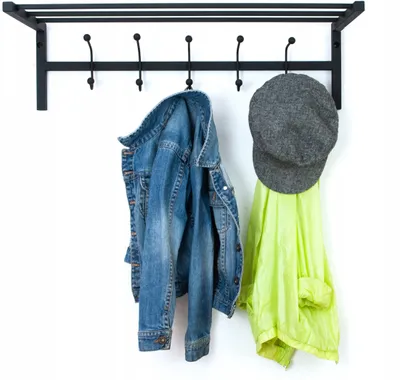 A black metal coat rack mounted on a white wall, with a denim jacket and a green jacket hanging on it, along with a gray cap.