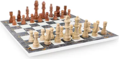 A chess set with wooden pieces on a marble-patterned board.