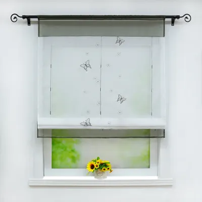 A window with a roman blind and a flower pot on the windowsill.
