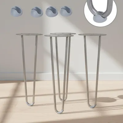 Four hairpin legs and four protective caps are displayed against a plain wall and wooden floor.