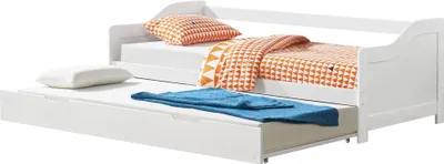 A white daybed with a pull-out trundle bed, both with mattresses. The daybed is dressed with orange and white patterned pillows and a matching blanket. A blue folded blanket lies on the trundle mattress.
