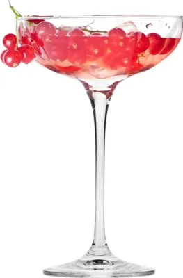 A clear glass coupe glass filled with a pink beverage and ice, garnished with red currants.
