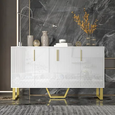A white sideboard with gold accents is displayed in a modern room with a marble-patterned wall.