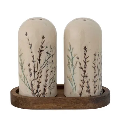A pair of ceramic salt and pepper shakers with a floral design, placed on a wooden tray.