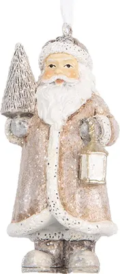 A Christmas ornament of Santa Claus holding a tree and a lantern.