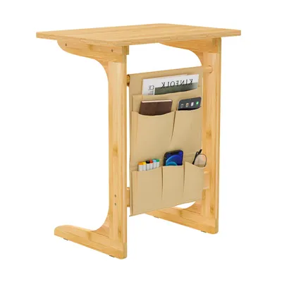 A bamboo side table with a fabric organizer attached to the side, filled with various items.