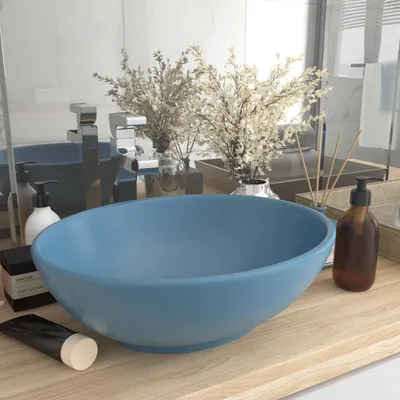 A bathroom sink with various toiletries on a wooden countertop.
