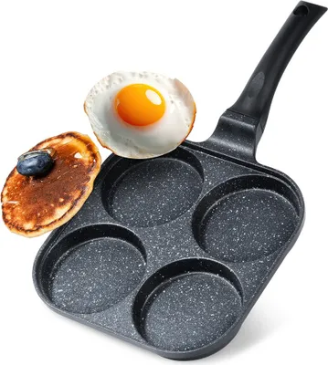 A frying pan with four circular molds, containing a fried egg and a pancake.