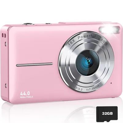 A pink digital camera with a silver lens and flash is shown against a white background. A 32GB memory card is placed in the foreground.