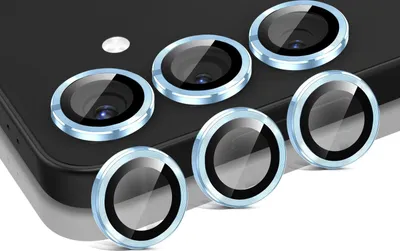 A close-up shot of multiple camera lens protectors arranged on a dark surface, likely a phone.