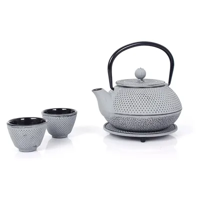 A cast iron teapot and two matching cups are displayed on a white background.
