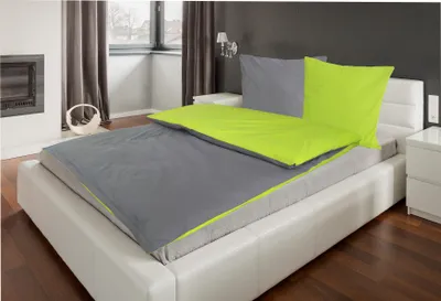 A bed with grey and green bedding in a bedroom.